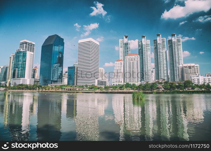 Lake and city buildings from Benjakitti Park in Bangkok.