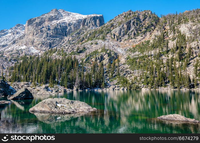 Lake Haiyaha, Rocky Mountains, Colorado, USA. . Lake Haiyaha with rocks and mountains in snow around at autumn. Rocky Mountain National Park in Colorado, USA.