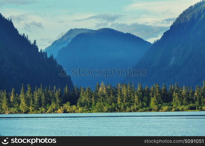 Lake in Canada. Serene scene by the mountain lake in Canada with reflection of the rocks in the calm water.