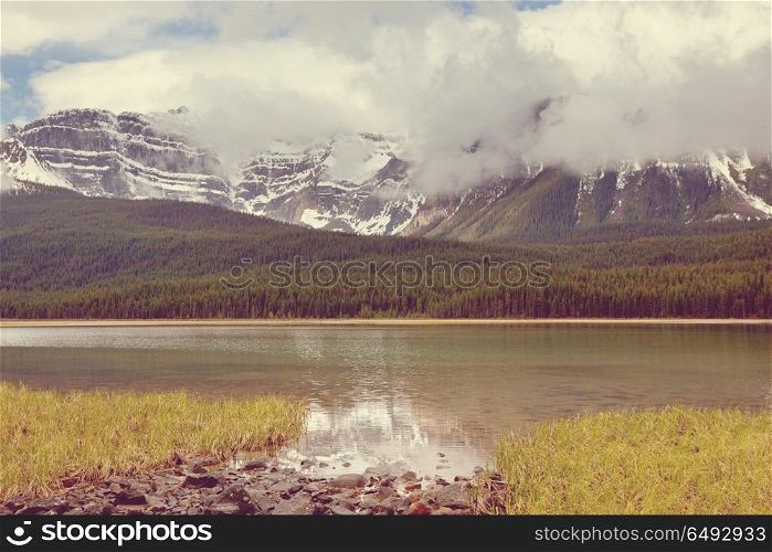Lake in Canada. Serene scene by the mountain lake in Canada with reflection of the rocks in the calm water.