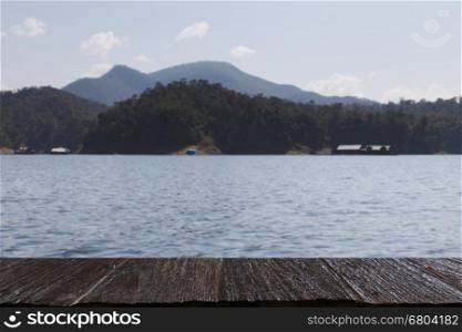 Lake in the mountains, Mae Ngad Dam and Reservoir in Thailand (blur image) with selected focus empty wood table for display your product