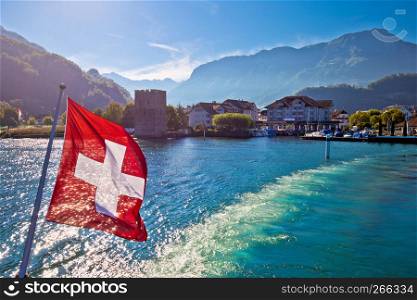 Lake Luzern boat flowing from Stansstad village with Swiss flag, fabulous landscape of Switzerland