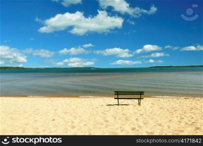 lake Michigan beach with bench and cloudy sky