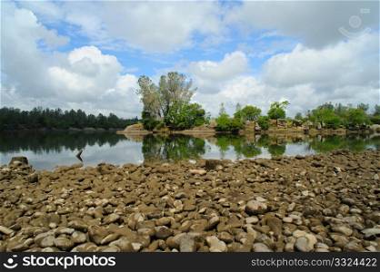 Lake Natoma in Folsom California, smooth as glass with a blue sky and clouds in the background,. Peaceful Lake Reflection