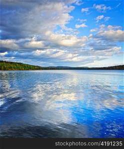 Lake of Two Rivers reflecting blue sky and clouds in Algonquin Park, Canada