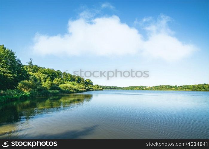 Lake scenery with green trees and blue sky