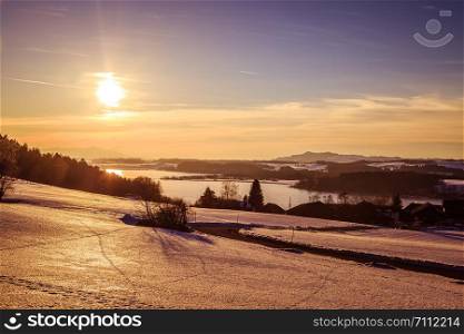 Lake, snowy fields and sundown: scenery at Wallersee, Austria