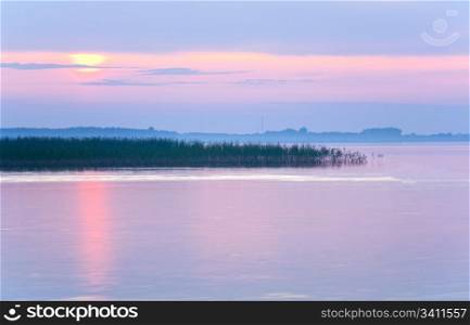 Lake sunset misty view with sunlight path on water surface (Svityaz, Ukraine)