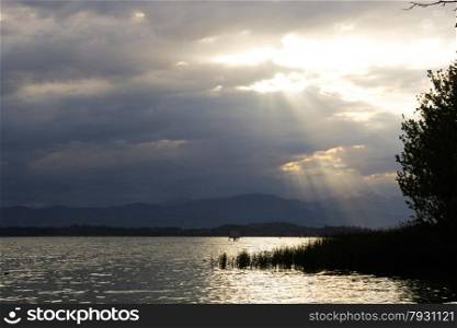 Lake Varese with the sun peeking out from the clouds