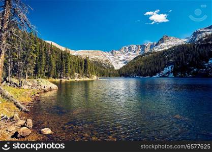 Lake Verna with rocks and mountains around at autumn. Rocky Mountain National Park in Colorado, USA. 