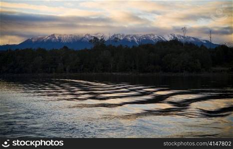 Lake water with snow capped mountains at sunrise