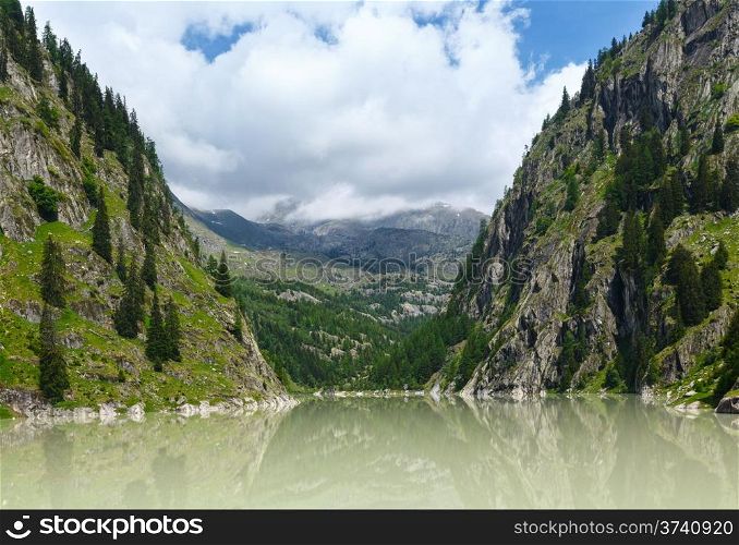 Lake with turbid water formed the dam. Summer mountain landscape (Alps, Switzerland)