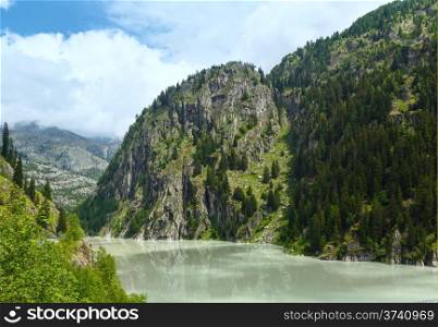 Lake with turbid water formed the dam. Summer mountain landscape (Alps, Switzerland)