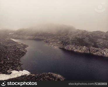 Lakes in stone rocky mountains, misty foggy day. Norway summer landscape. Norwegian national tourist scenic route Ryfylke.. Lakes in mountains Norway