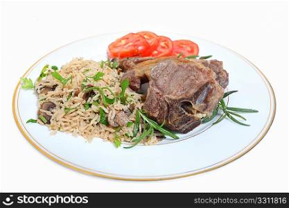 Lamb chops served with mushroom rice pilau and sliced tomatoes, garnished with rosemary.