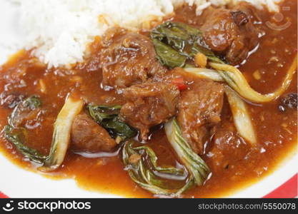 Lamb curried with anise and bok choi (pak soi) leaves, served with jasmine rice. Viewed from the side