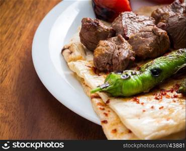 Lamb kebabs with flatbread, tomato and pepper