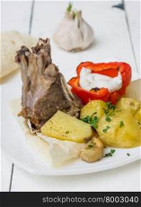 lamb loin chops with baked potatoes on wooden table