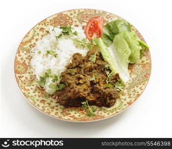 "Lamb or "ghosht" dry fried curry in the Pakistani or north Indian style, served with basmati rice garnished with coriander leaves, and a lettuce and tomato salad."