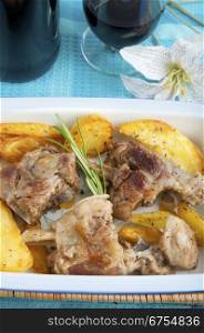 Lamb roast with potatoes and a glass of red wine
