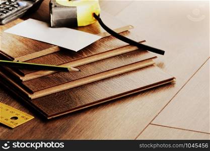 Laminate floor planks and tools on wooden background.. Laminate floor planks and tools on wooden background