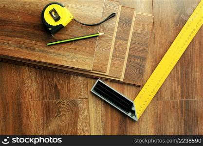 Laminate floor planks and tools on wooden background.. Laminate floor planks and tools on wooden background. Top view.