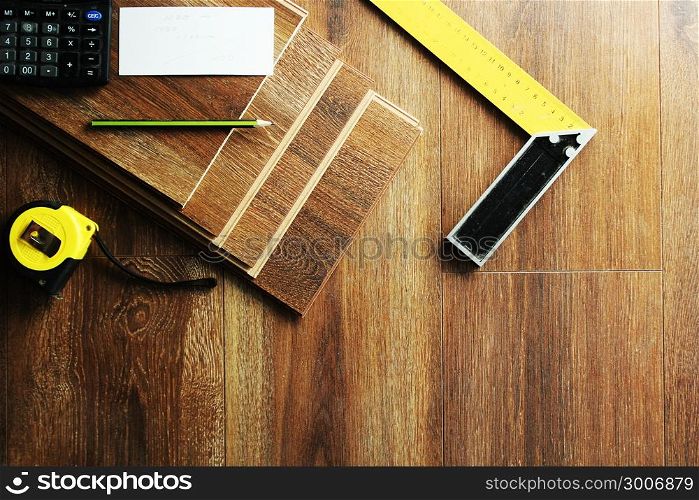 Laminate floor planks and tools on wooden background. Laminate floor planks and tools on wooden background.