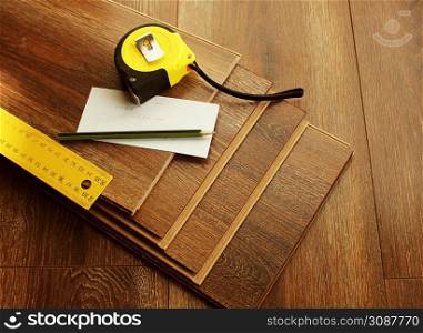 Laminate floor planks and tools on wooden background. Different carpenter tools on the laminated floor .Top view .. Laminate floor planks and tools on wooden background. Different carpenter tools on the laminated floor .Top view