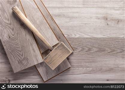 Laminate wood floor and hammer tool for flooring. Wooden laminate background texture