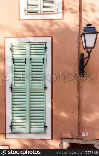 Lamp and window with shutters in Villefranche sur Mer, France