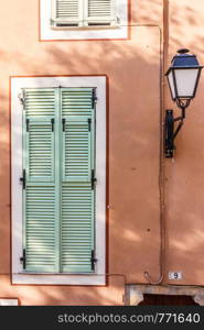 Lamp and window with shutters in Villefranche sur Mer, France