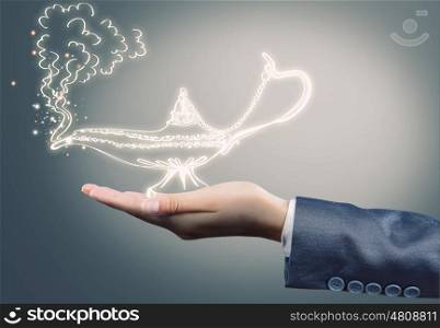 Lamp of wishes. Close up of businessperson hand holding lamp in hand