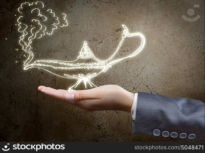 Lamp of wishes. Close up of businessperson hand holding lamp in hand