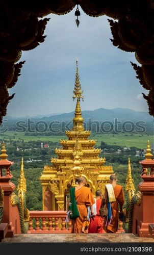 Lampang, Thailand - Sep 04, 2019 : Buddhist Monks are walking into down the gate of Wat Phra That Doi Phra Chan in Lampang. A temple on the top of a mountain the north of thailand. No focus, specifically.