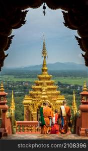 Lampang, Thailand - Sep 04, 2019 : Buddhist Monks are walking into down the gate of Wat Phra That Doi Phra Chan in Lampang. A temple on the top of a mountain the north of thailand. No focus, specifically.
