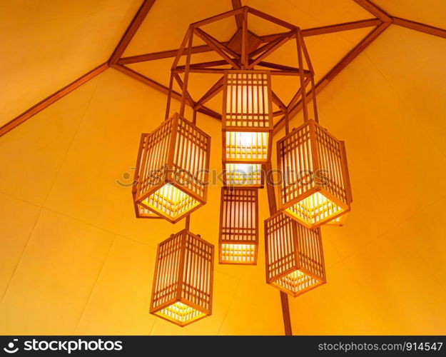 Lamps wooden wicker hanging on ceiling in the room. Decorating interior lantern concept.