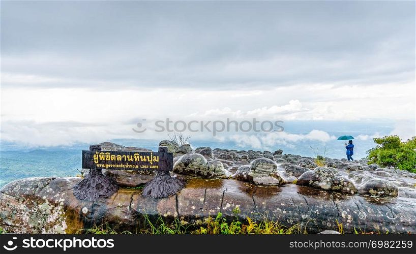 Lan Hin Pum Nameplate tourist group and large stone courtyard while the rain is falling with strange stone shapes is a famous nature attractions of Phu Hin Rong Kla National Park, Phitsanulok,Thailand. Lan Hin Pum Nameplate