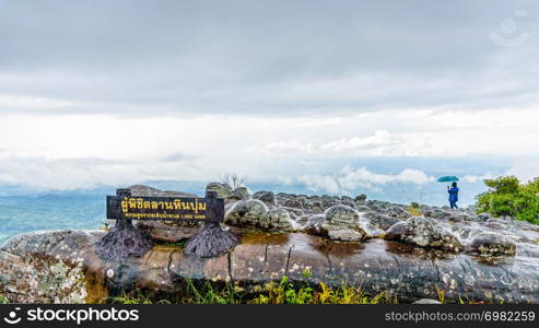 Lan Hin Pum Nameplate tourist group and large stone courtyard while the rain is falling with strange stone shapes is a famous nature attractions of Phu Hin Rong Kla National Park, Phitsanulok,Thailand. Lan Hin Pum Nameplate