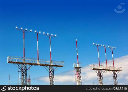 Landing lights towers in white and red over blue sky in Canary Islands