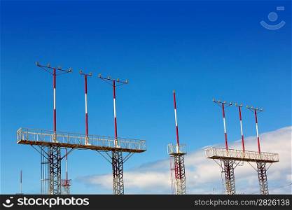 Landing lights towers in white and red over blue sky in Canary Islands