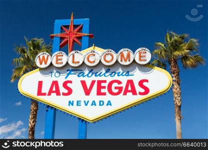 landmarks concept - welcome to fabulous las vegas sign and palm trees over blue sky in united states of america. welcome to fabulous las vegas sign and palm trees