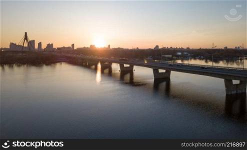 Landscape and sunset with suspension north Bridge across the Dnieper river, Obolon district in Kiev, Ukraine. Photo from the drone. Sunset of north bridge over the Dnieper River, Kiev.