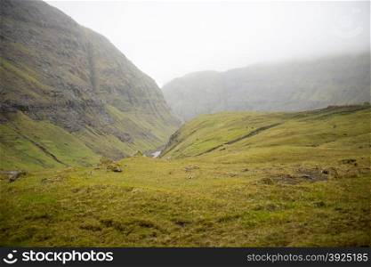 Landscape around Saksun. Landscape around Saksun on the Faroe Islands with canyon grass and mountain