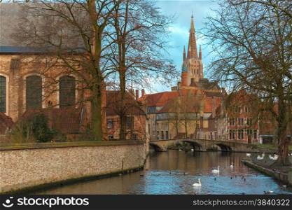 Landscape at Lake Minnewater, church and bridge in Bruges, Belgium