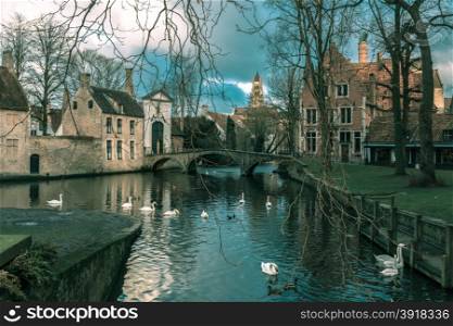 Landscape at Lake Minnewater with church and bridge in Bruges, Belgium. Toning in cool tones