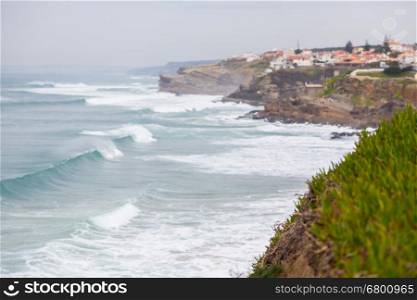 landscape atlantic coastline with stones, plants and surfs in cloudy day