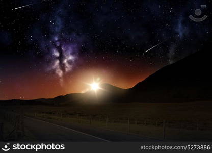 landscape concept - mountains over sunrise in night sky or space with shooting stars background. landscape over sunrise in night sky or space