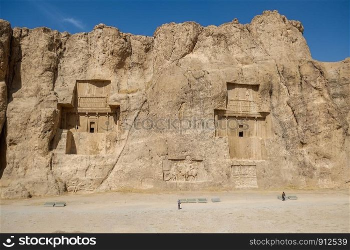 Landscape famous landmark of the ancient Naqsh-e Rustam shows large tombs cut high into the cliff face. Fars Province, Iran.