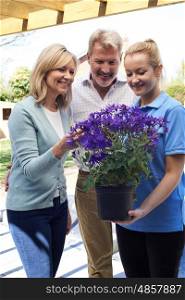 Landscape Gardener Advising Mature Couple On Garden Plants