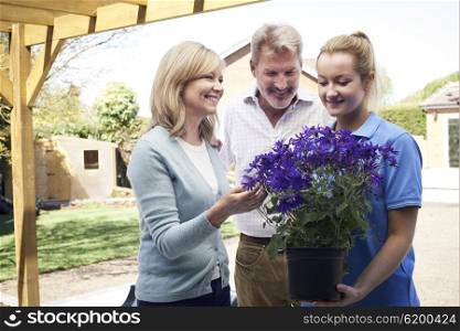 Landscape Gardener Advising Mature Couple On Garden Plants
